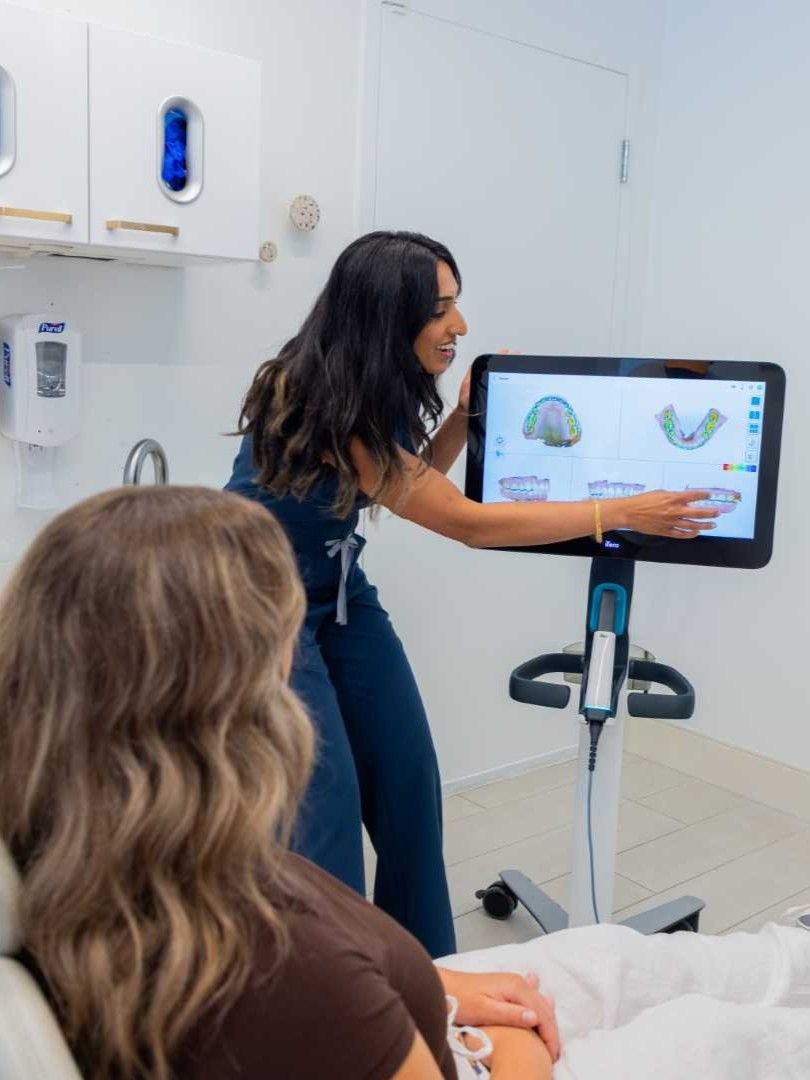 Canary Dental dentist explaining digital 3D dental scan to patient on a large monitor in clinic room