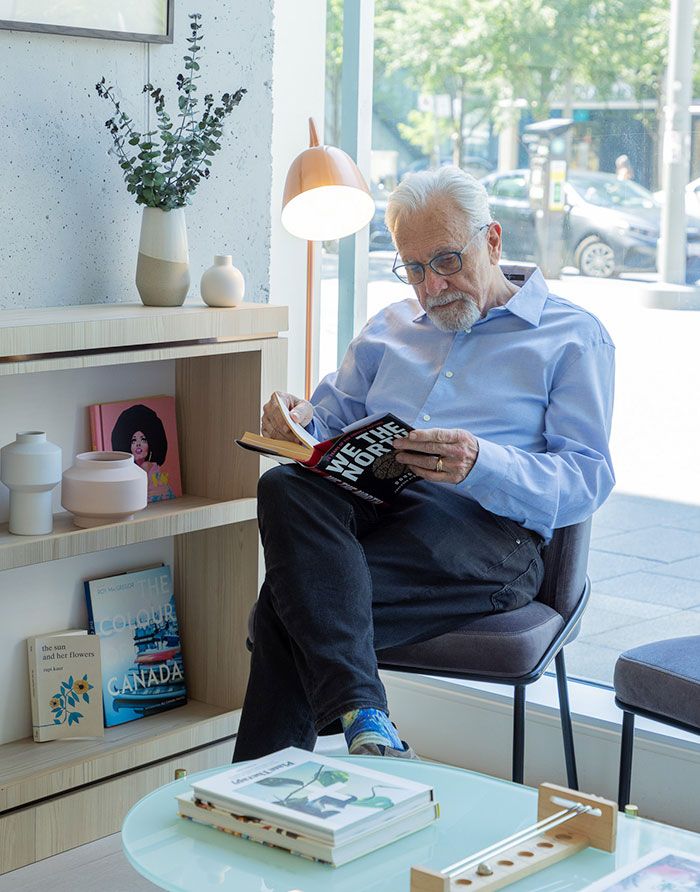 Canary Dental waiting area with a relaxed man reading a book by the bright street-facing window