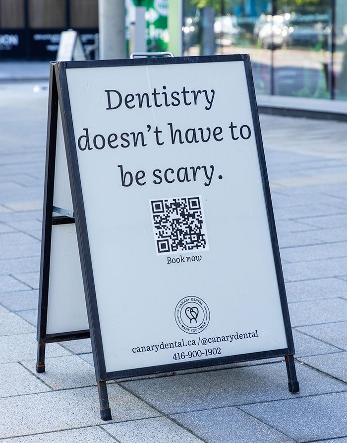 canary-dental-general-dentistry-dental-care-experience-5 Canary Dental sidewalk sign with QR code and message “Dentistry doesn’t have to be scary”