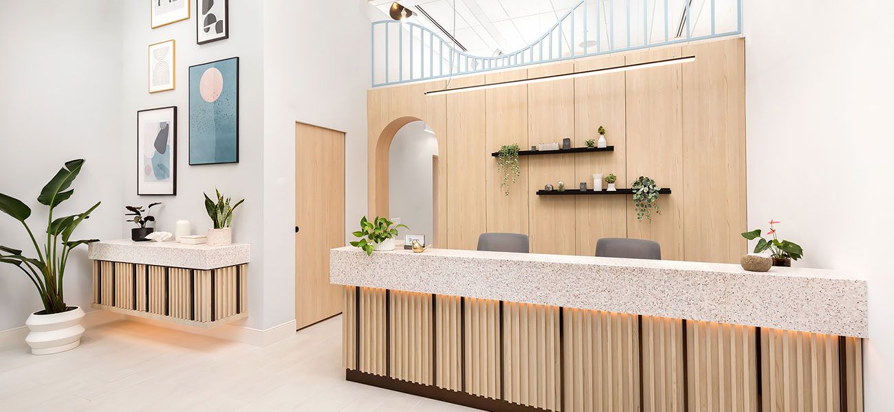 Canary Dental reception area with modern wood accents, soft lighting, and stylish framed wall art